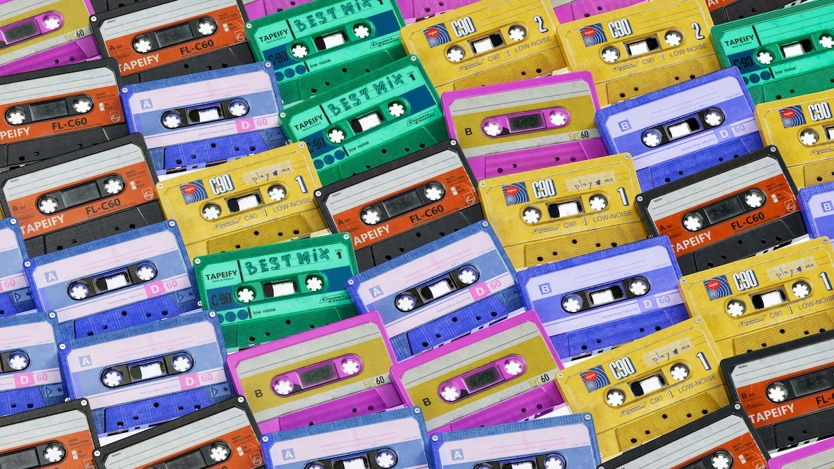 Colorful cassette tapes all stacked upon each other in neat rows in colors of black, blue, yellow, green, and hot pink
