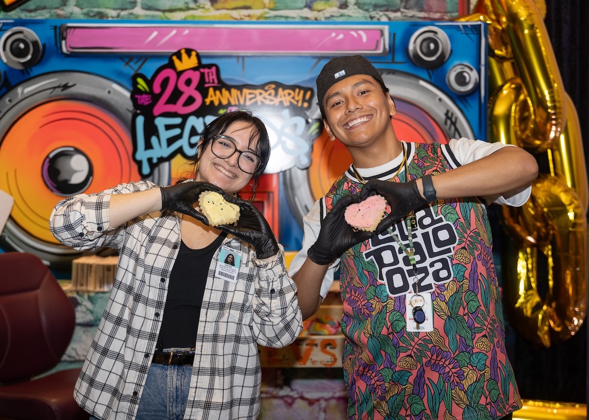 Gabi and Cole smile holding heart-shaped cookies at the 2026 Legends Casino Hotel 28th Anniversary Party