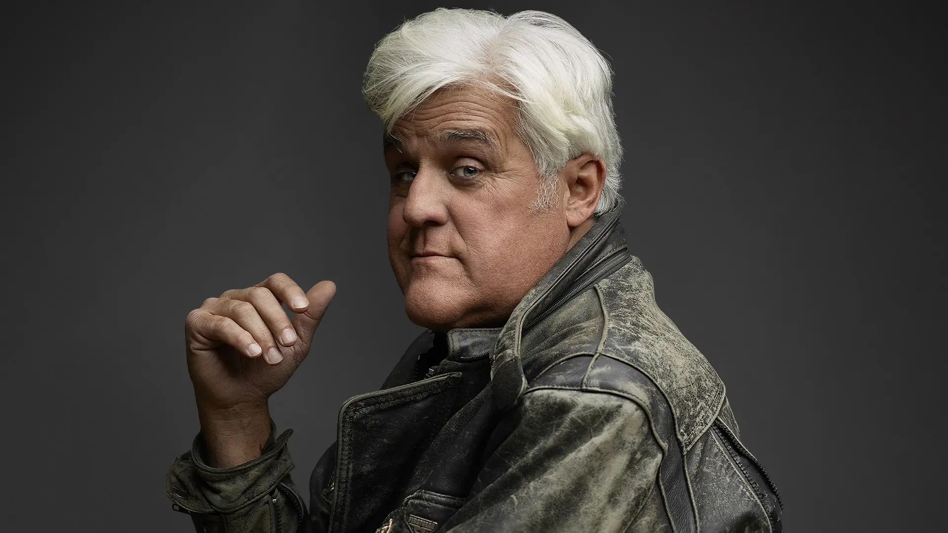Headshot of Jay Leno smirking at the camera