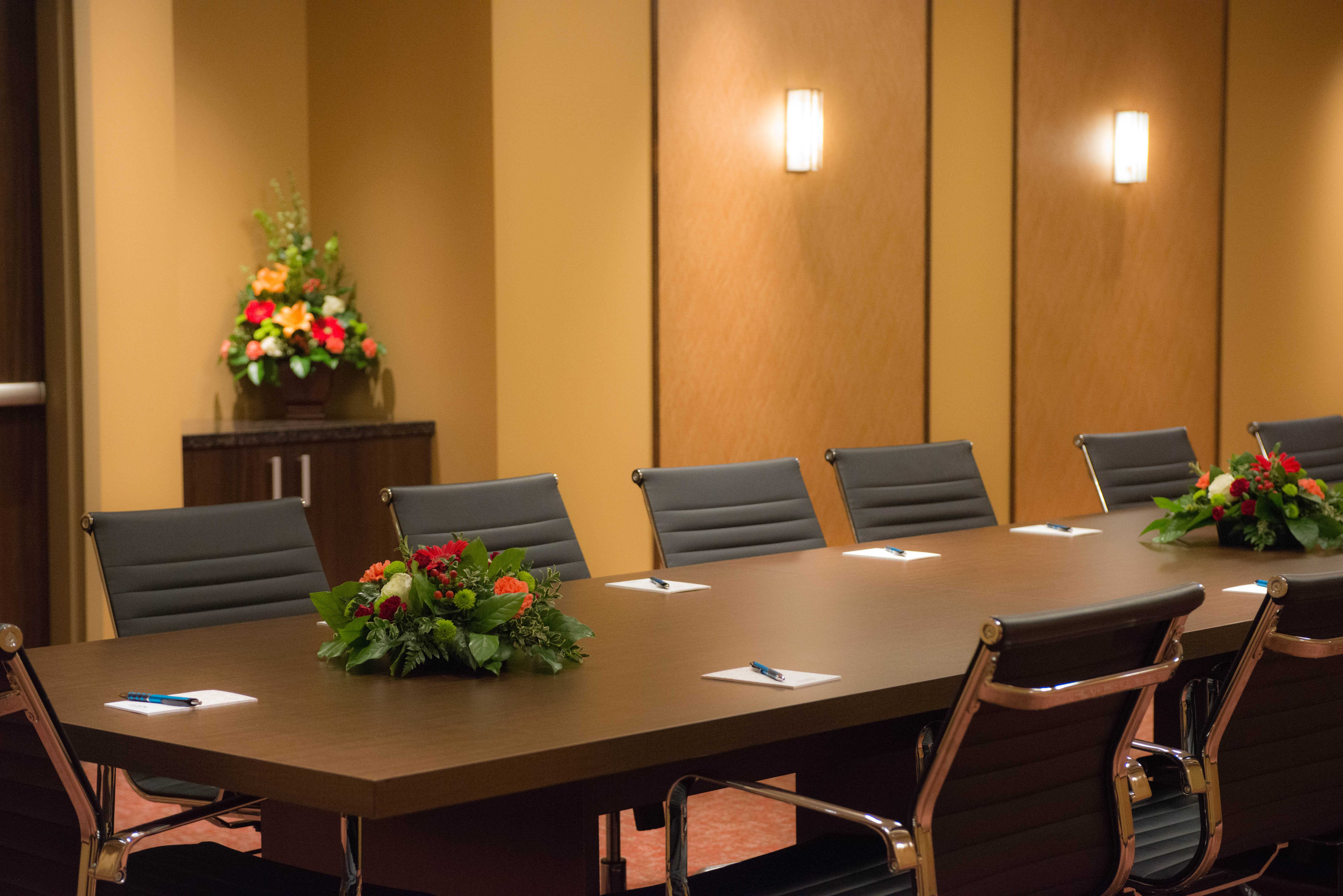 Sala de reuniones del Legends Hotel Klickitat, con flores frescas sobre la mesa y una mesita auxiliar al fondo