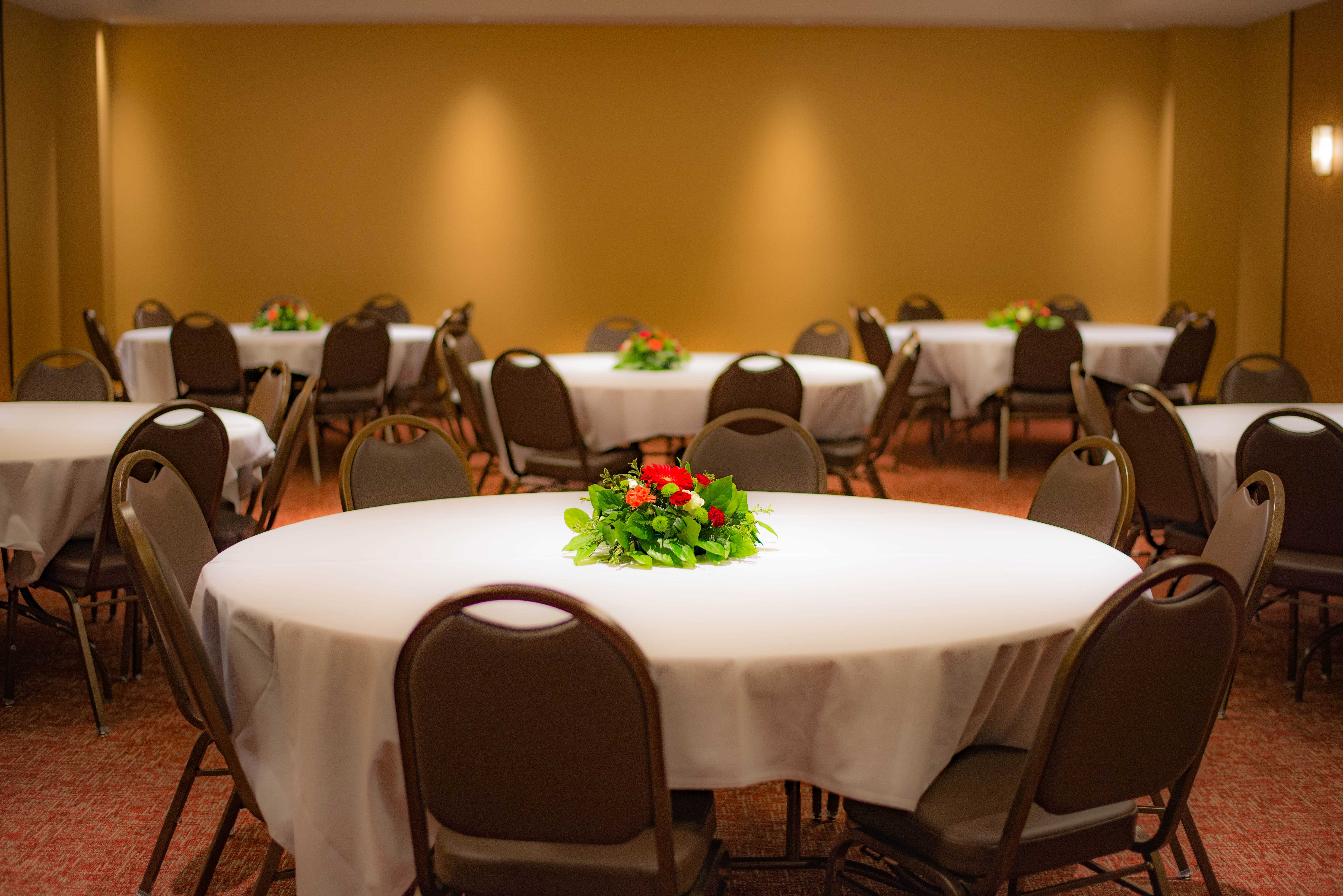 Una vista del amplio espacio de reuniones Yakama del Legends Casino Hotel, decorado con manteles blancos sobre una variedad de grandes mesas redondas.